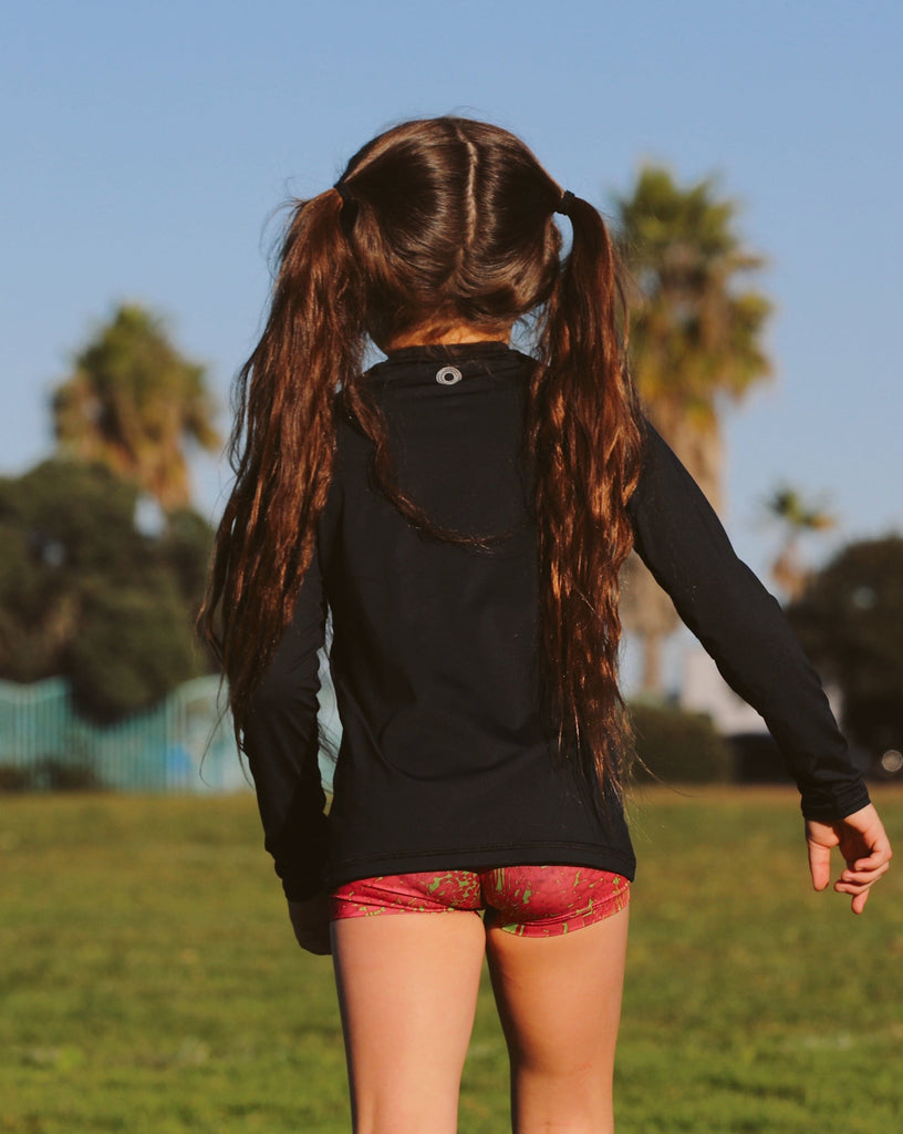 Girl wearing black color top while running in a soccer field. (Style 1005K) - BloqUV