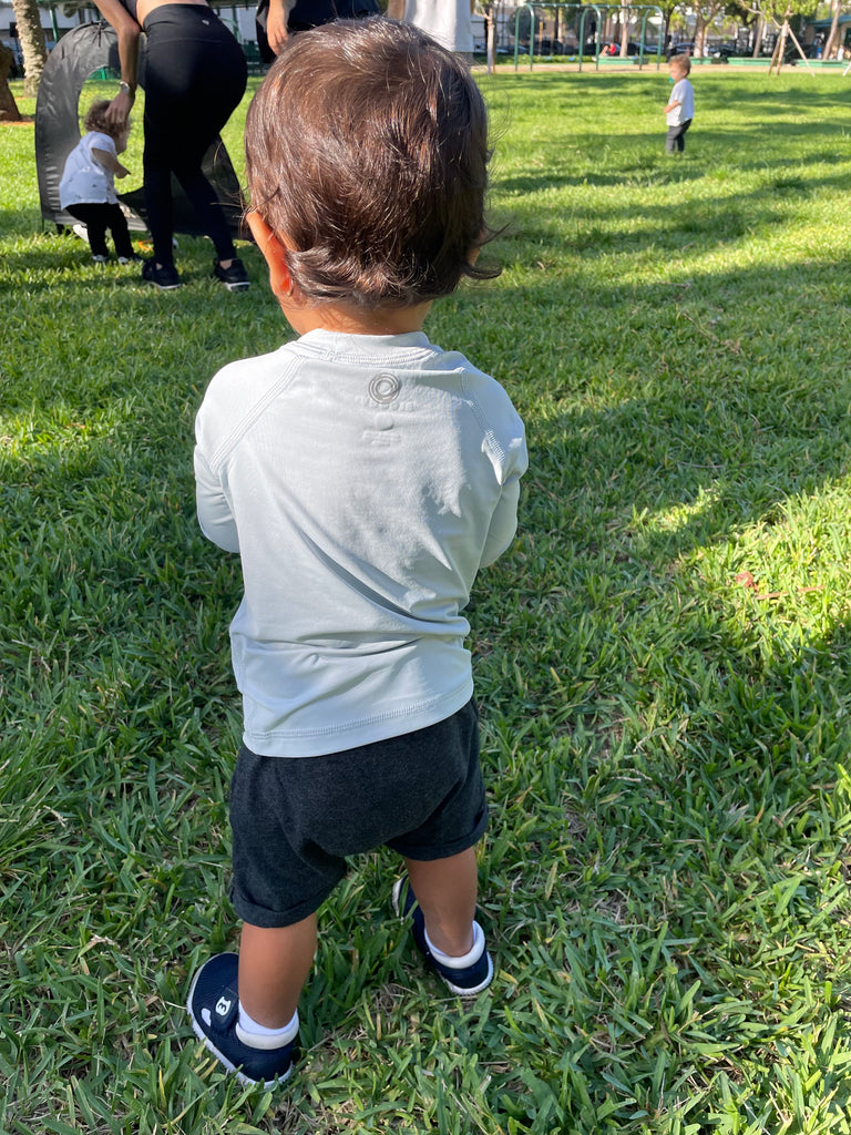 Toddler boy playing at the park wearing soft grey crew neck top. (Style 1005T) - BloqUV