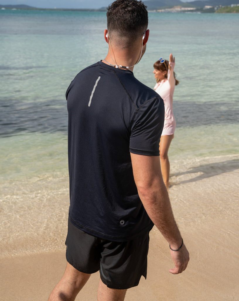 Man at the beach wearing short sleeve crew shirt in black. (Style 11002) - BloqUV