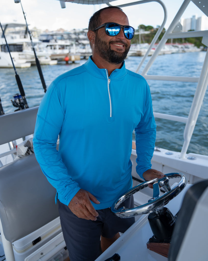 Man on boat wearing long sleeve mock zip shirt in ocean blue. (Style 12001) - BloqUV