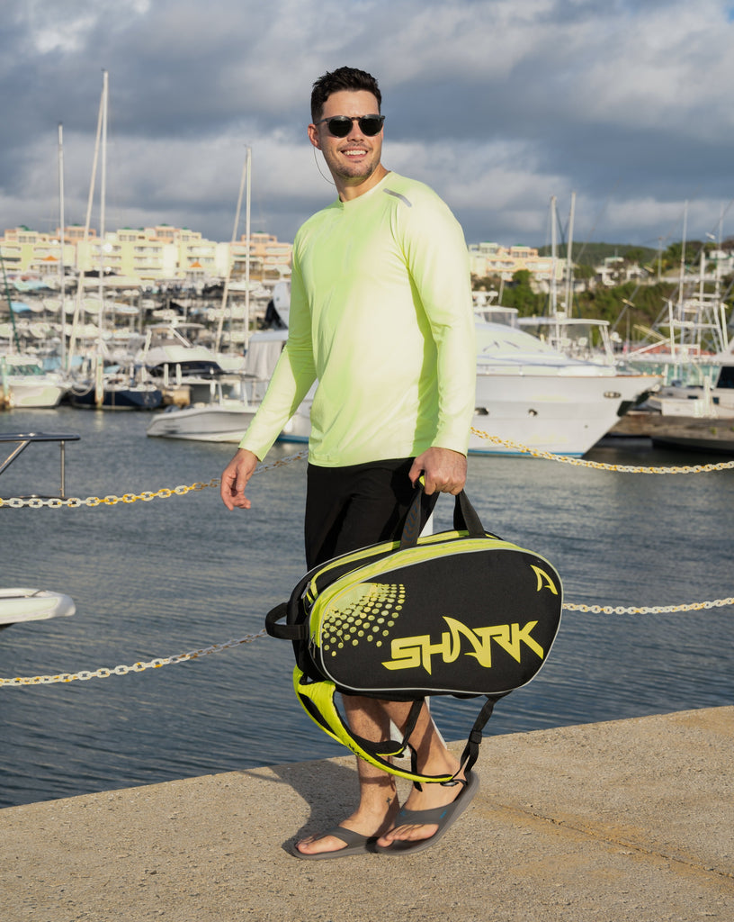 Man standing in marina wearing long sleeve jet tee shirt in neon yellow. (Style 12002) - BloqUV