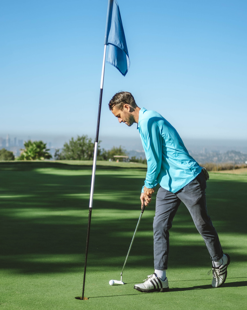 Man wearing long sleeve collared shirt in light turquoise playing golf. (Style 12004) - BloqUV