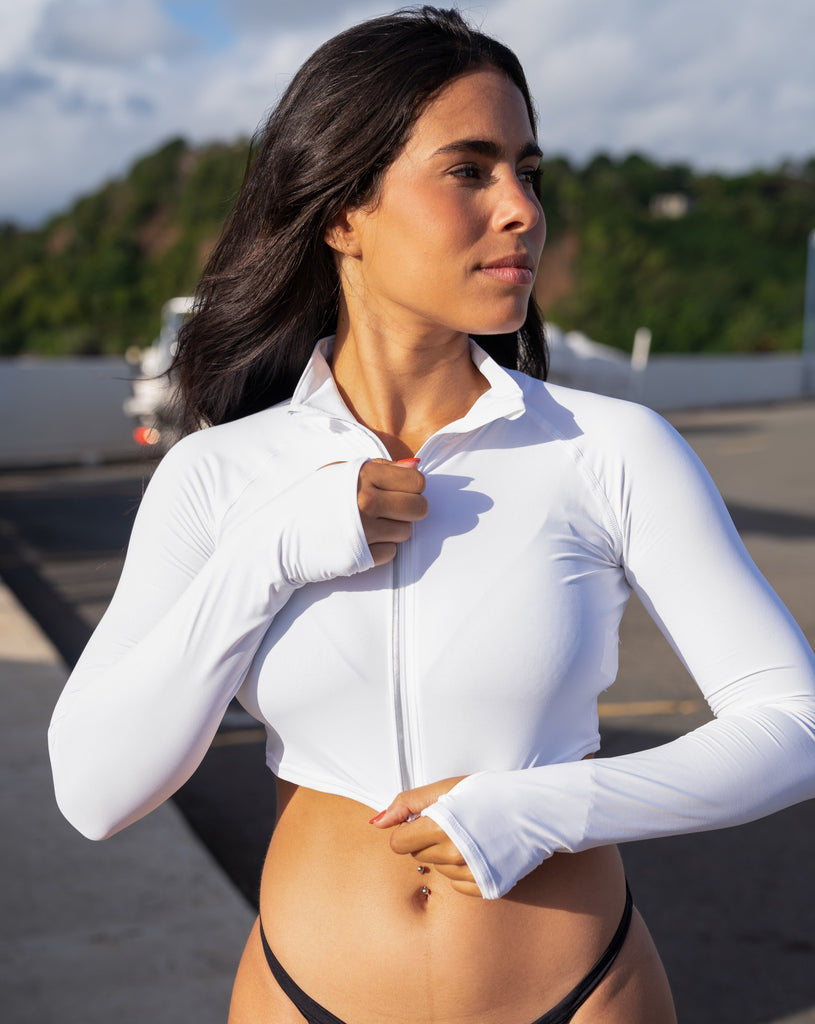 Women standing in a marina wearing white turquoise full zip crop top over tank top with black swim bottom. (Style 4010) - BloqUV