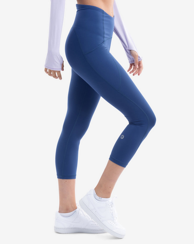Women wearing compression capri leggings in navy. Side view showing pocket. (Style 6103) -BloqUV