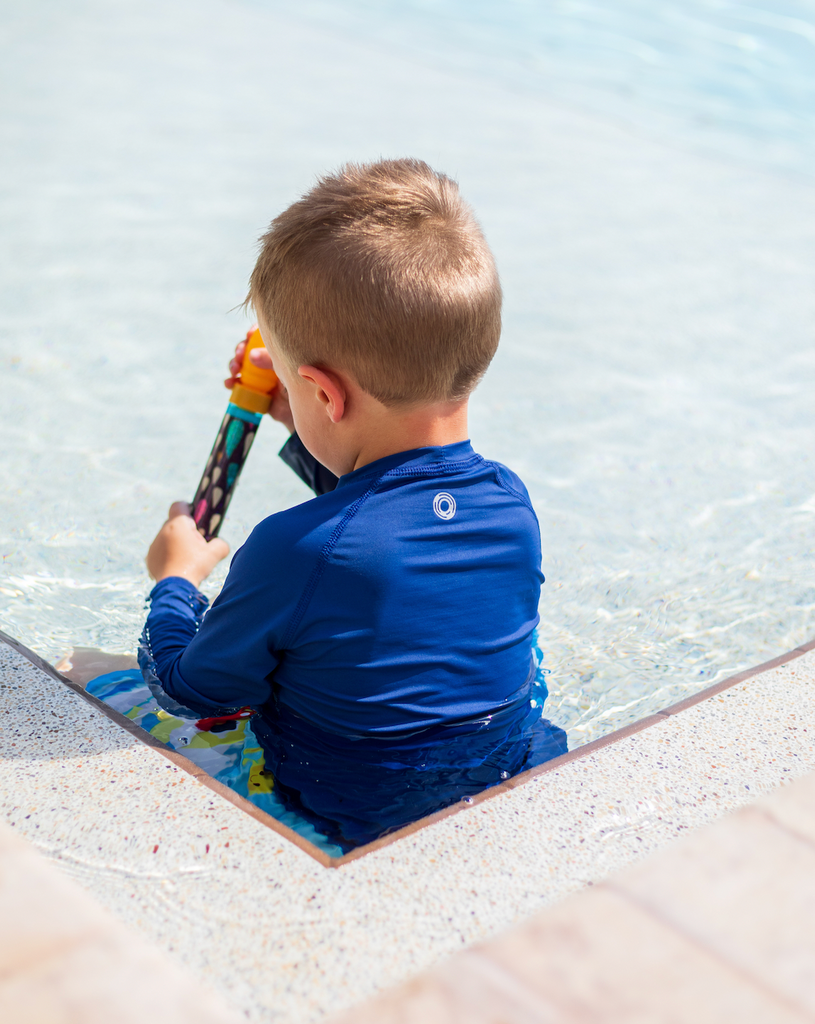 Toddler boy sitting at the pool wearing navy crew neck top. (Style 1005T) - BloqUV