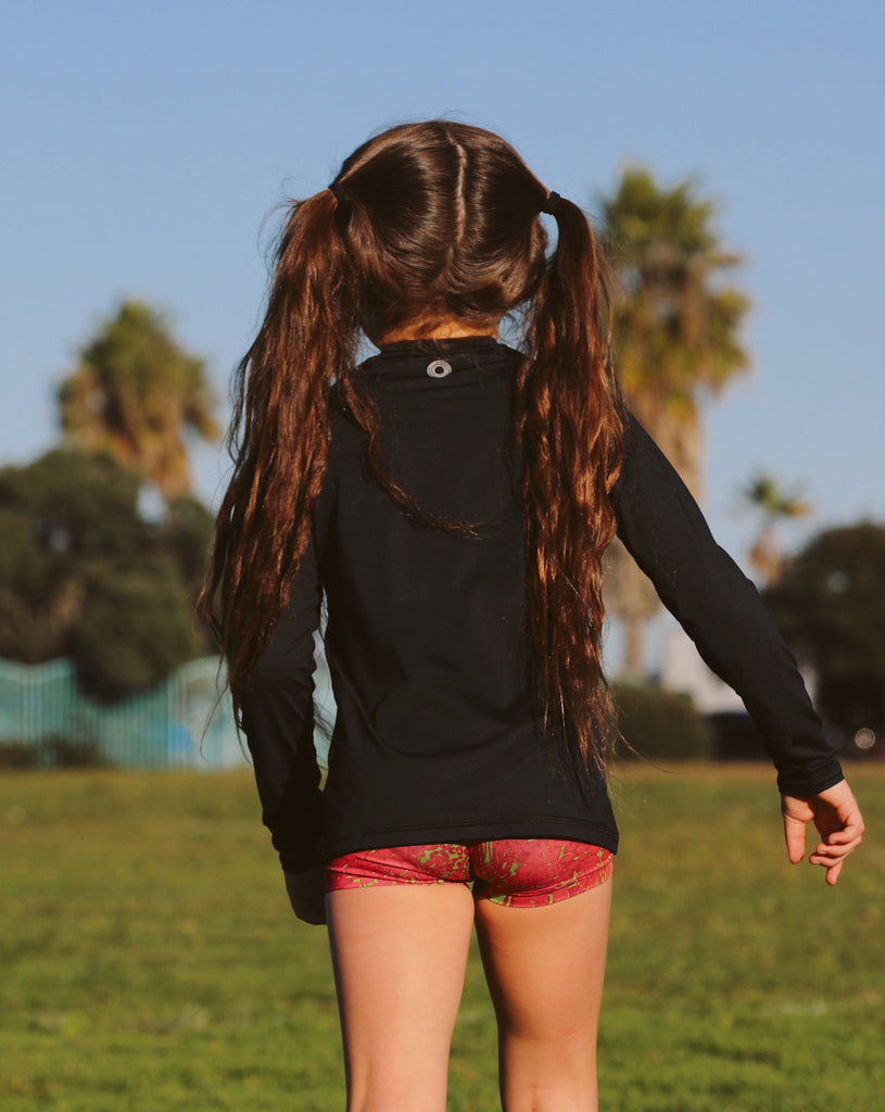 Girl wearing black color top while running in a soccer field. (Style 1005K) - BloqUV