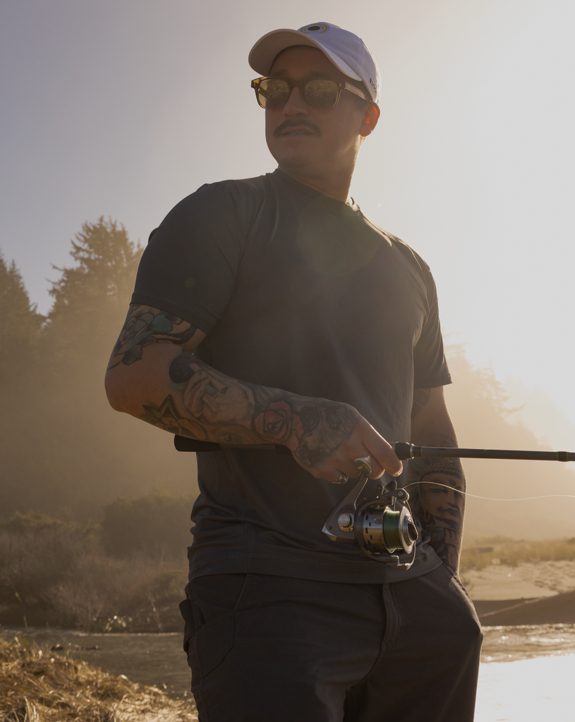 Man holding a fishing rod wearing short sleeve crew shirt in smoke. (Style 11002) - BloqUV