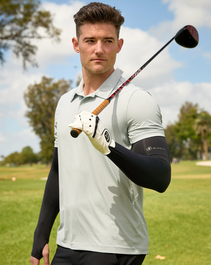 Man standing at the golf course wearing black color unisex sleeves with short sleeve soft grey jet tee. (Style 5005) - BloqUV