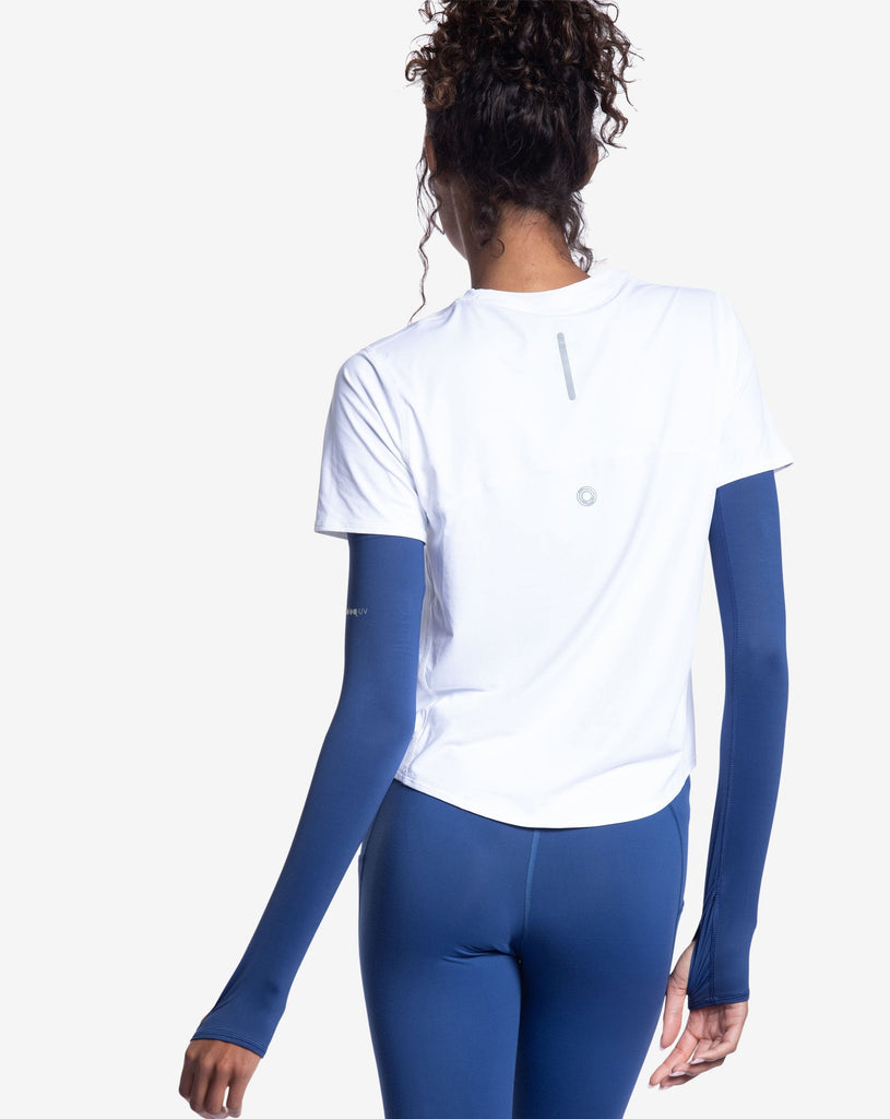 Women wearing white short sleeve crew top with navy sun sleeves and navy tights. Picture shows back of image showing reflector. (Style 1101) - BloqUV