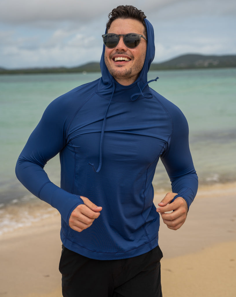 Man at beach  wearing midnight blue color unisex long sleeve hoodie shirt. (Style 12007) - BloqUV