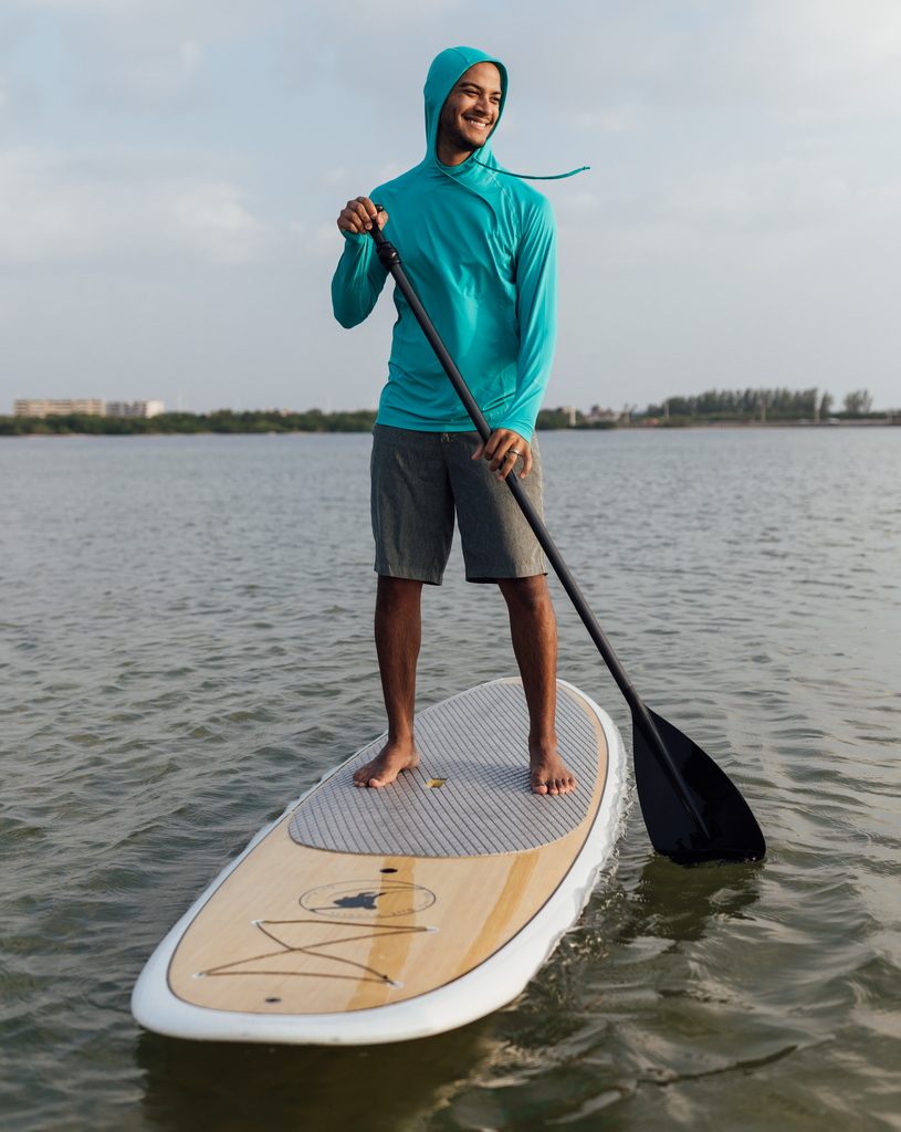 Man paddle boarding wearing caribbean blue color unisex long sleeve hoodie shirt. (Style 12007) - BloqUV