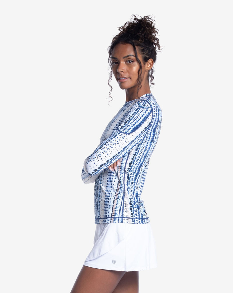 Women wearing printed top with water dunes print long sleeve 24/7 shirt with white skirt. Picture shows the side of the shirt with pocket on sleeve. (Style 2001J) - BloqUV