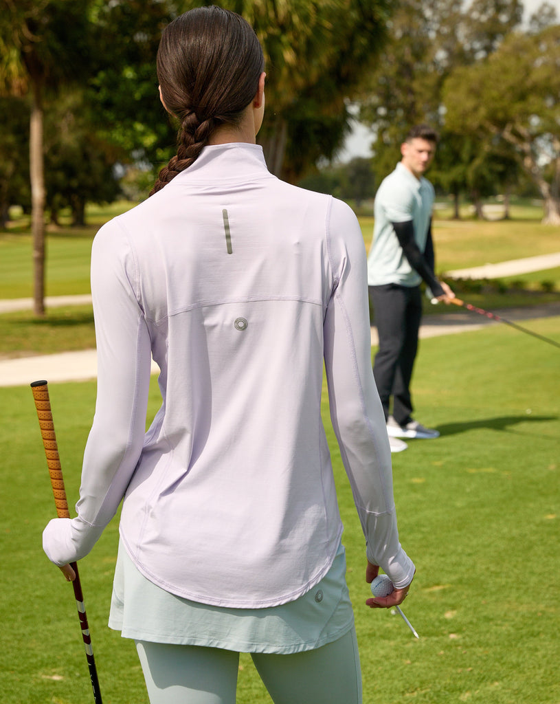 Women playing golf wearing lavender relaxed mock zip top with soft grey skort. (Style 3002) - BloqUV