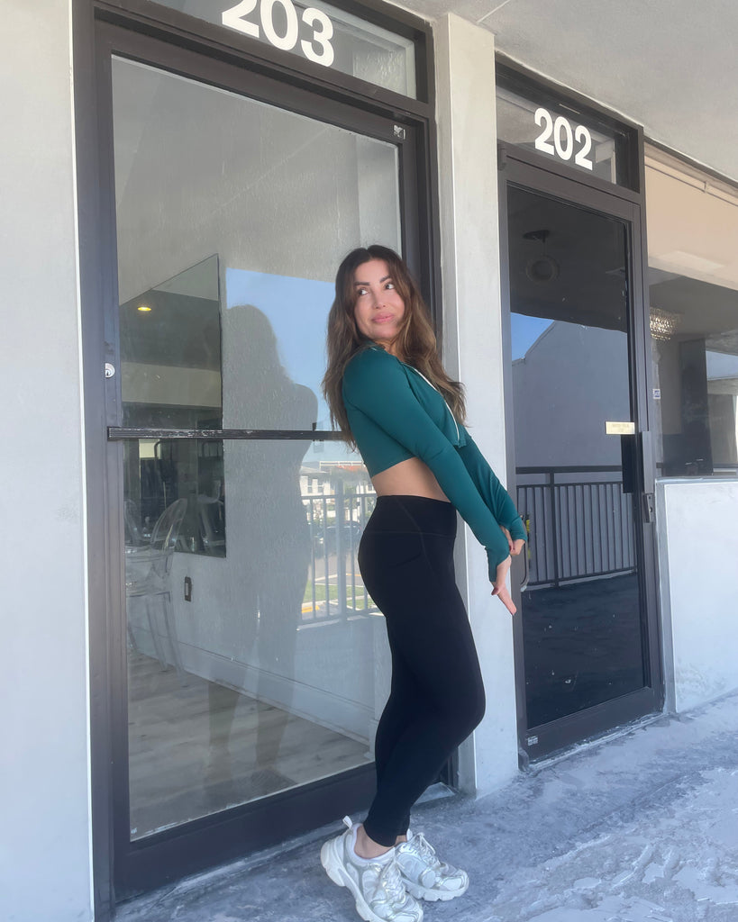 Woman posing in front of a building with numbers 202 and 203.