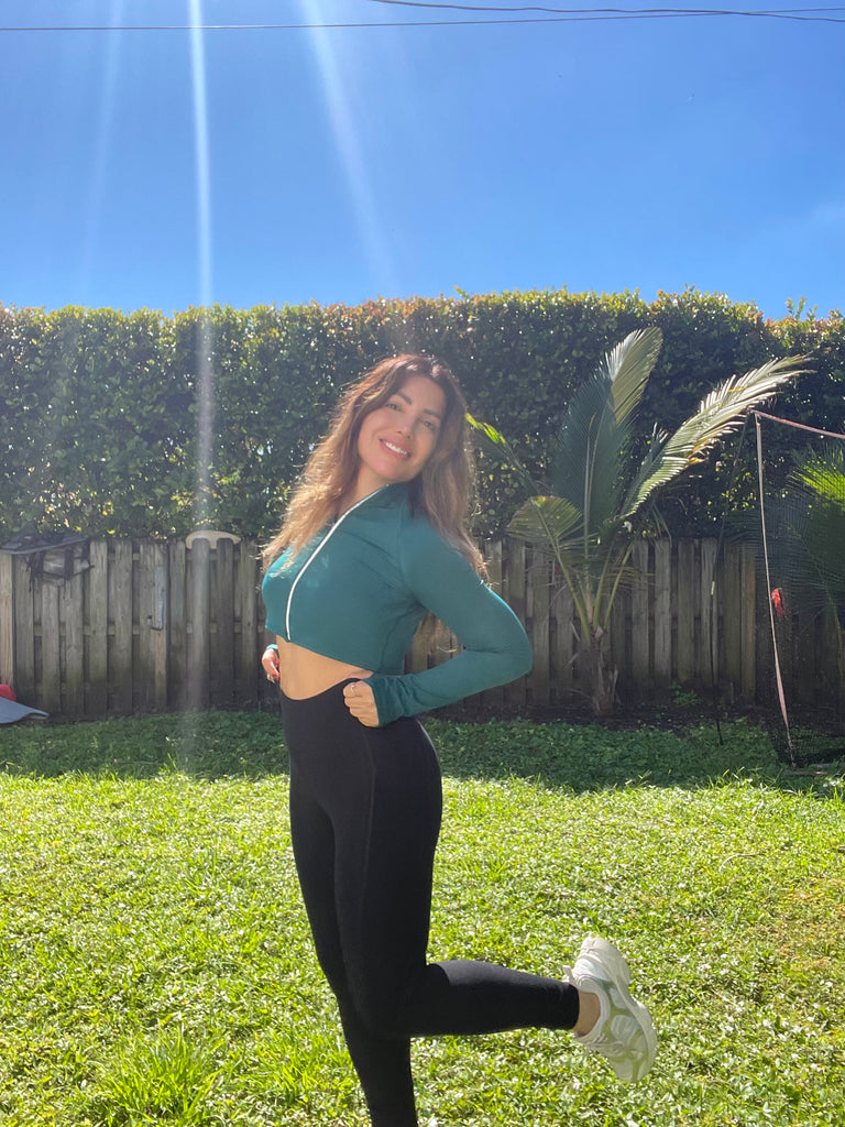 Woman in athletic wear standing outdoors on a sunny day