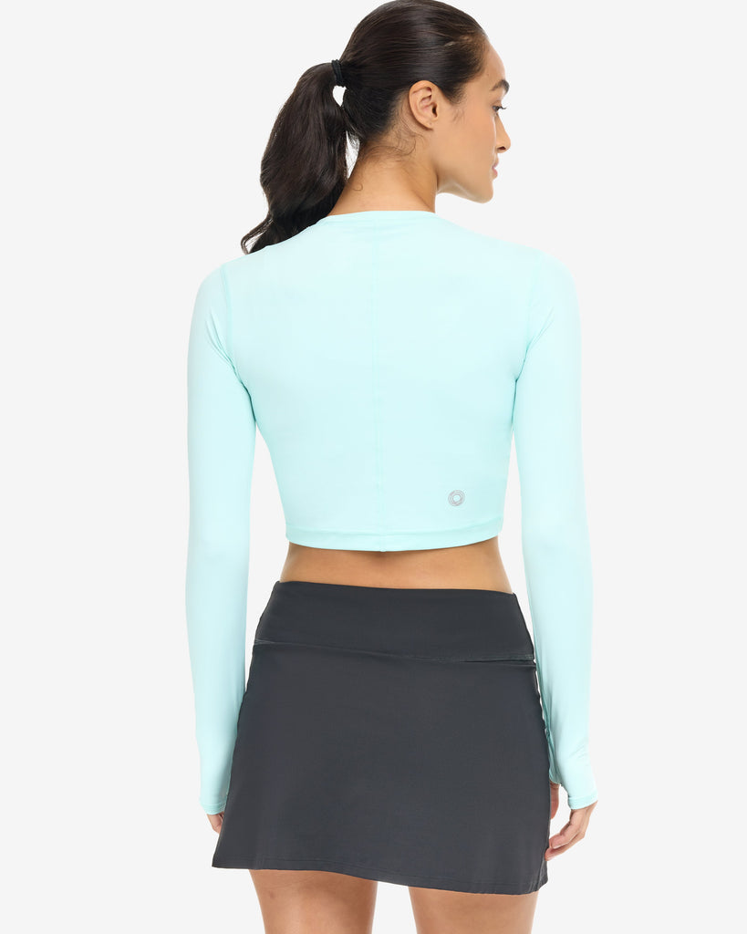 Women wearing everyday crop top in mint with black skort - back shown. (Style 6100) - BloqUV