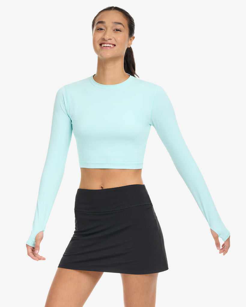 Women wearing everyday crop top in mint with black skort. (Style 6100) - BloqUV