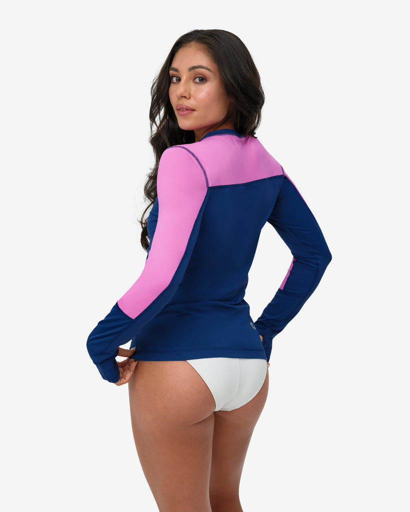 Woman wearing a blue and pink long-sleeve top with white underwear on a white background
