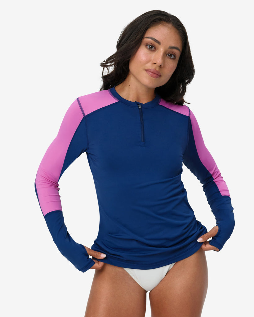 Woman wearing a blue and pink long-sleeve rash guard on a white background