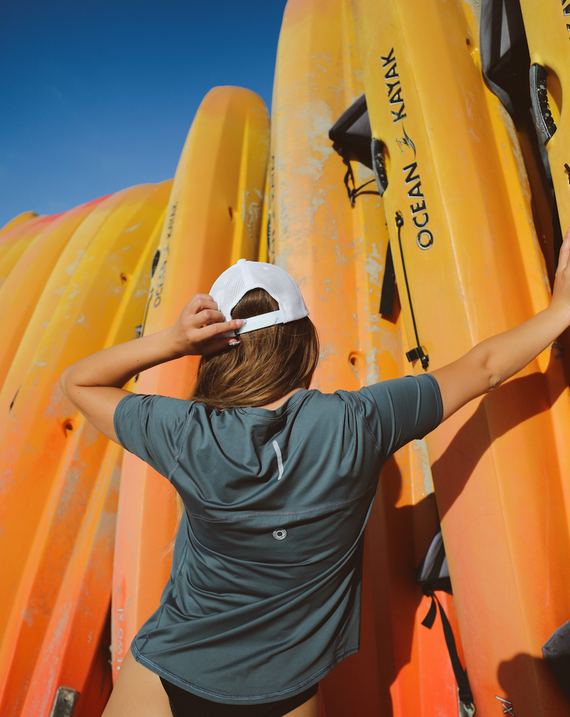 Women standing with kayaks wearing smoke short sleeve crew top with black joggers tights. Picture shows reflector in the back of the shirt. (Style 1101) - BloqUV