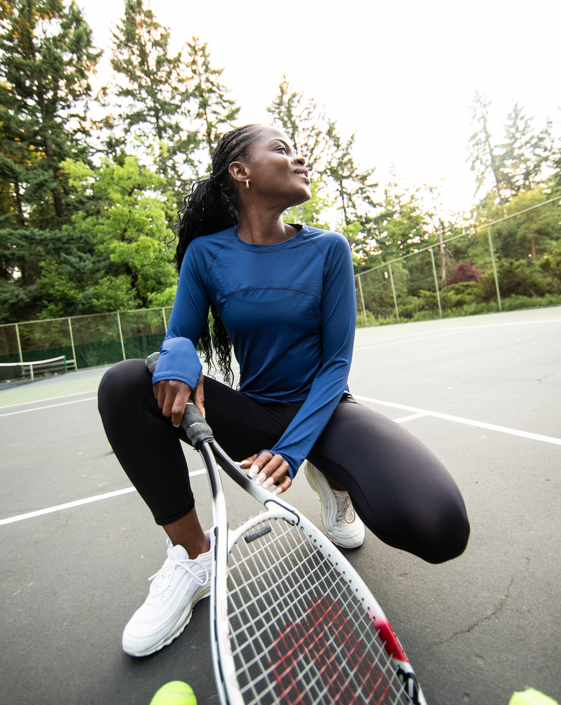 Women in tennis court wearing navy long sleeve drawstring crew with black tights.  (Style 2006) - BloqUV