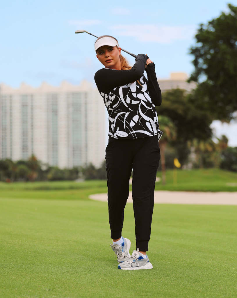 Women playing golf wearing printed black and white long sleeve relaxed mock zip with black joggers. (Style 3002J) - BloqUV