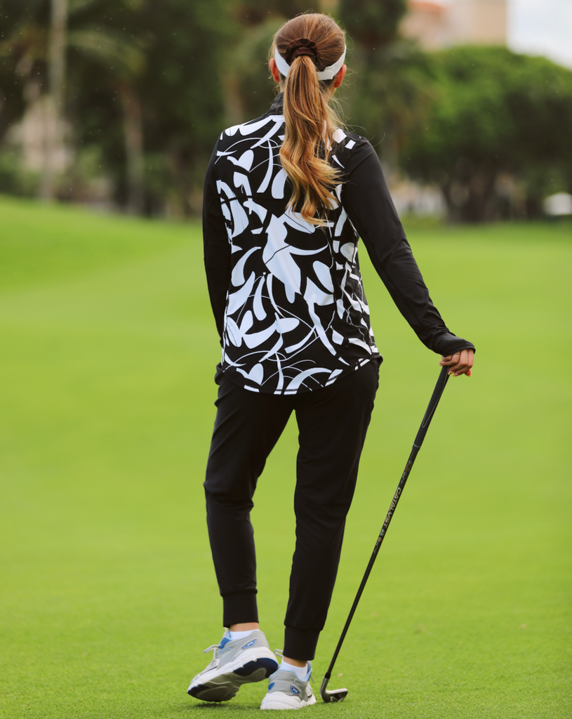 Women playing golf wearing printed black and white long sleeve relaxed mock zip with black joggers. Picture shows back of shirt. (Style 3002J) - BloqUV