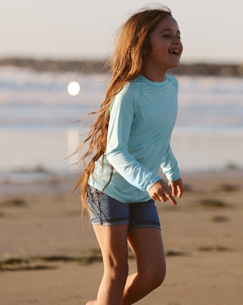 Girl wearing mint color top while playing at the beach. (Style 1005K) - BloqUV