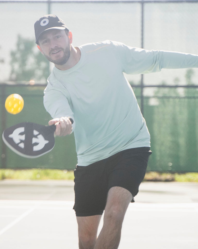 Man playing pickleball wearing long sleeve jet tee shirt in sage. (Style 12002) - BloqUV