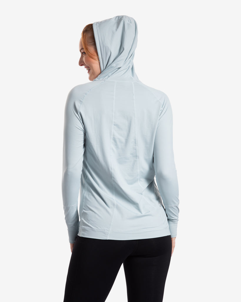 Women wearing soft grey color unisex long sleeve hoodie shirt. Picture shows hoodie covering the head.  (Style 12007) - BloqUV