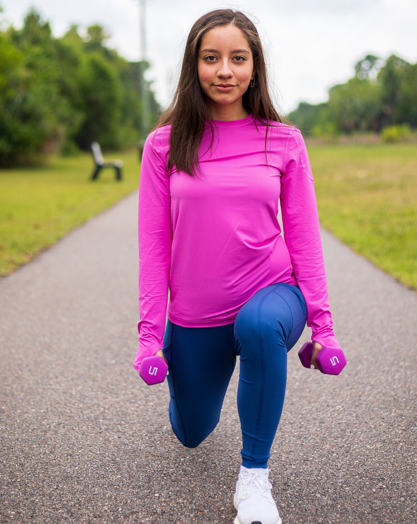 Women working out outside wearing bubble gum long sleeve 24/7 shirt with navy tights. (Style 2001) - BloqUV