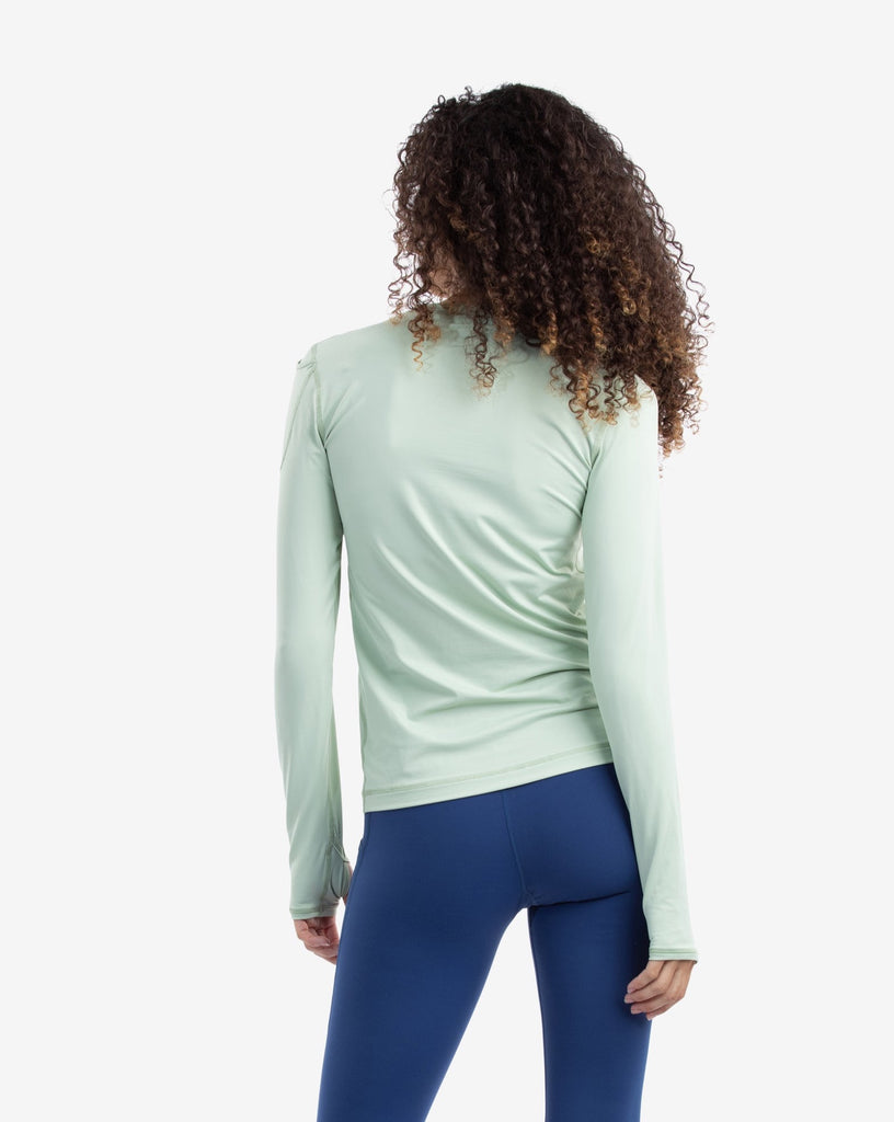 Women wearing sage long sleeve 24/7 shirt with navy tights. Picture shows the back of the shirt. (Style 2001) - BloqUV