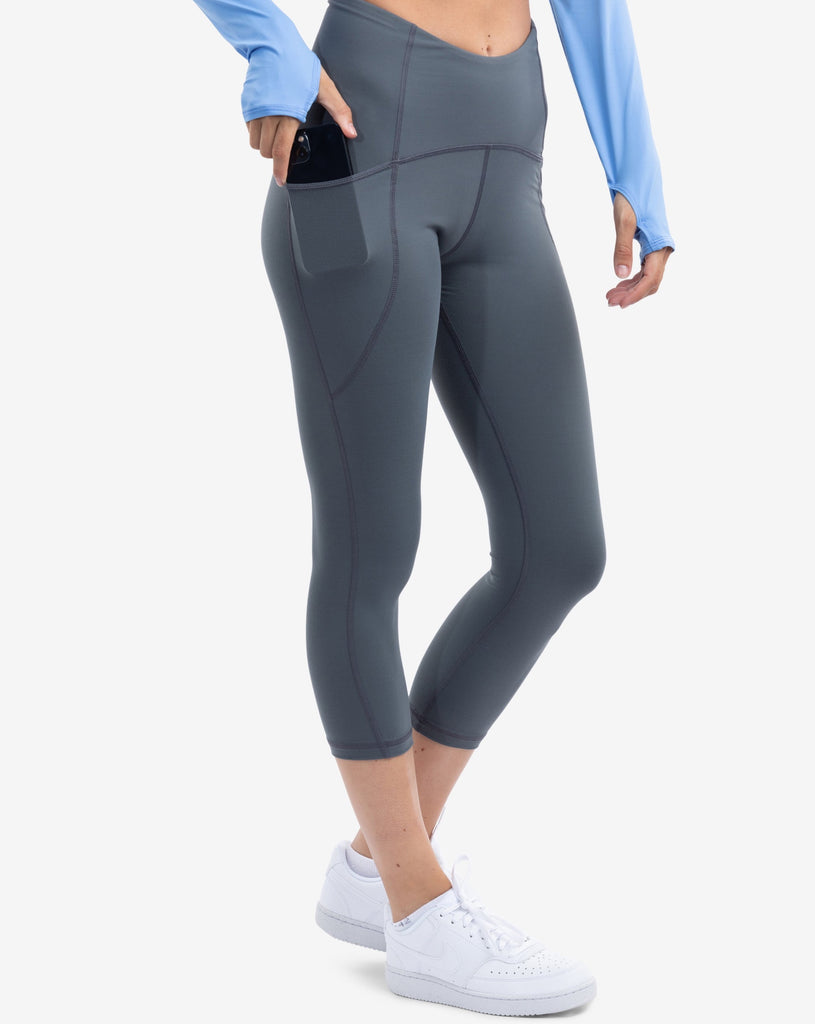 Women wearing compression capri leggings in smoke. Side view showing pocket with cell phone inside. (Style 6103) -BloqUV