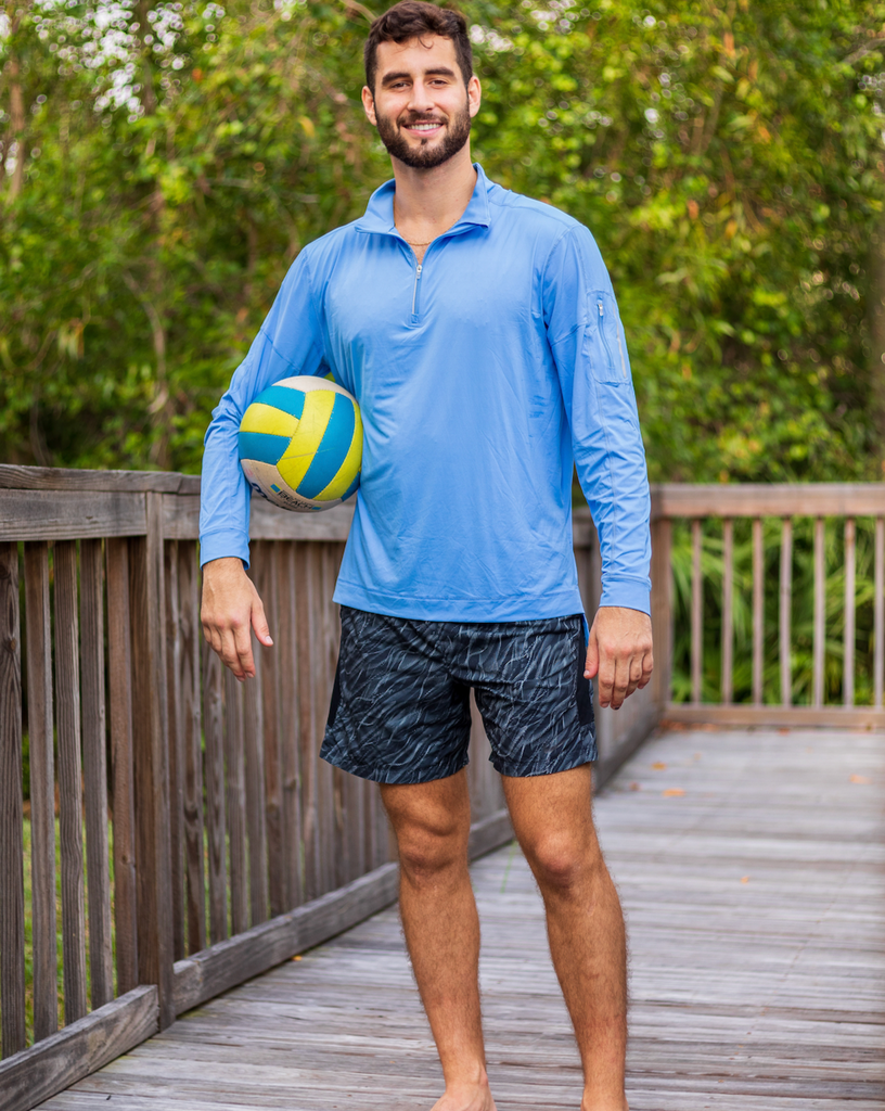 Man holding a volleyball wearing long sleeve mock zip shirt in indigo (Style 12001) - BloqUV
