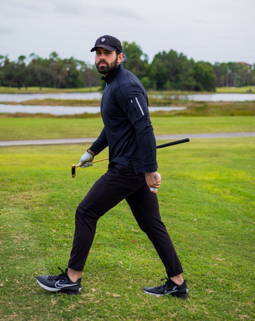 Man playing golf wearing long sleeve mock zip shirt in black (Style 12001) - BloqUV