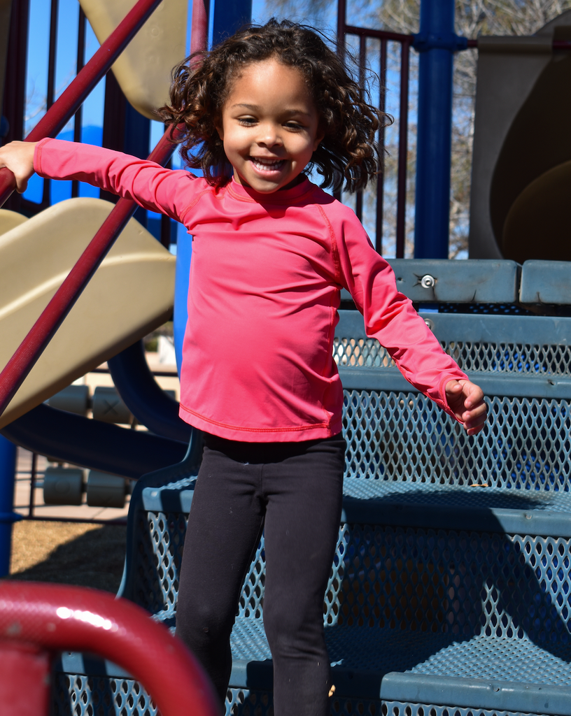 Toddler girl playing at the park wearing watermelon crew neck top. (Style 1005T) - BloqUV